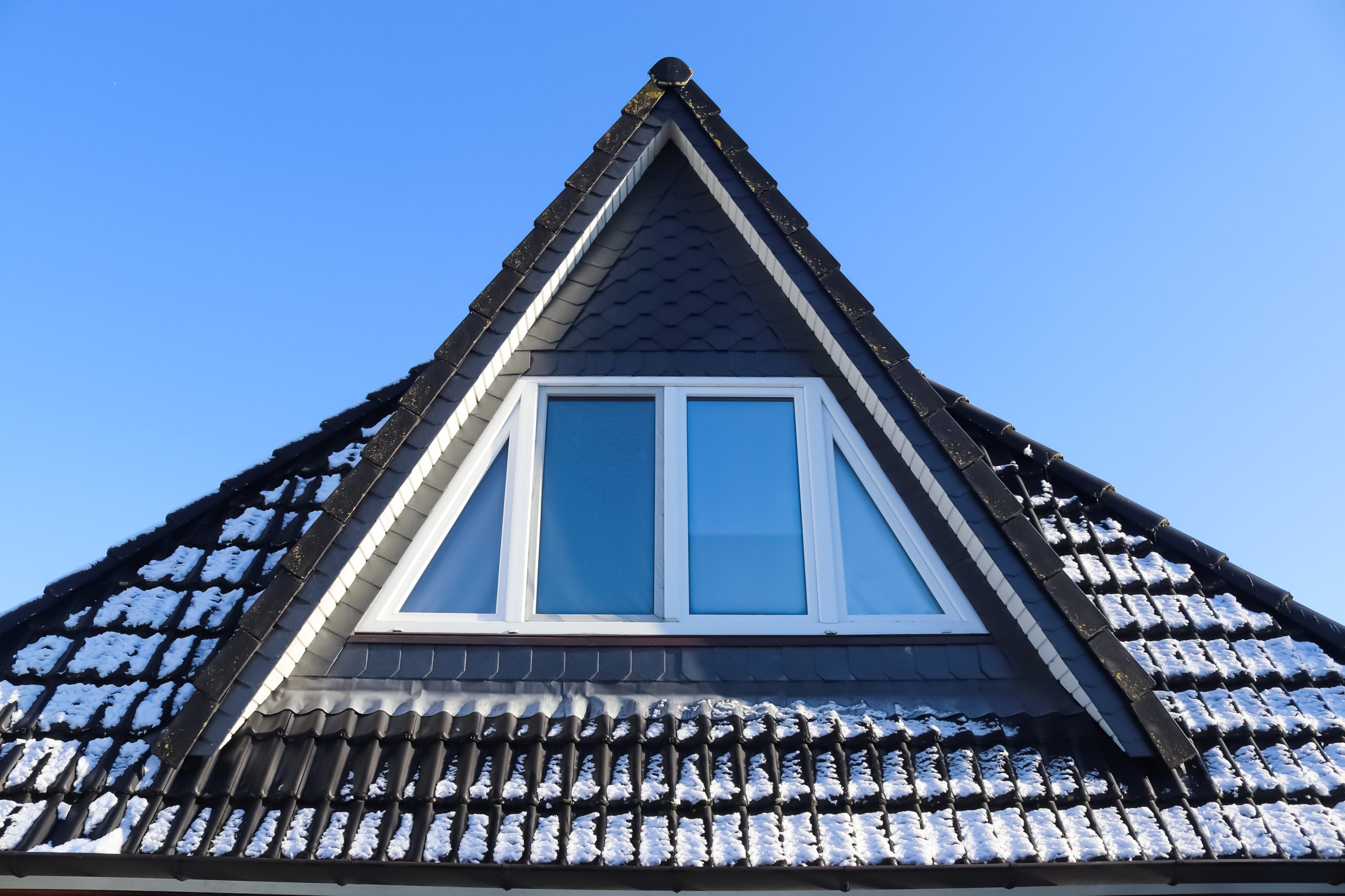 A triangular rooftop room window from outside